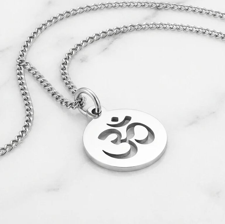 Silver necklace with a pendant featuring an Om symbol on a marble background