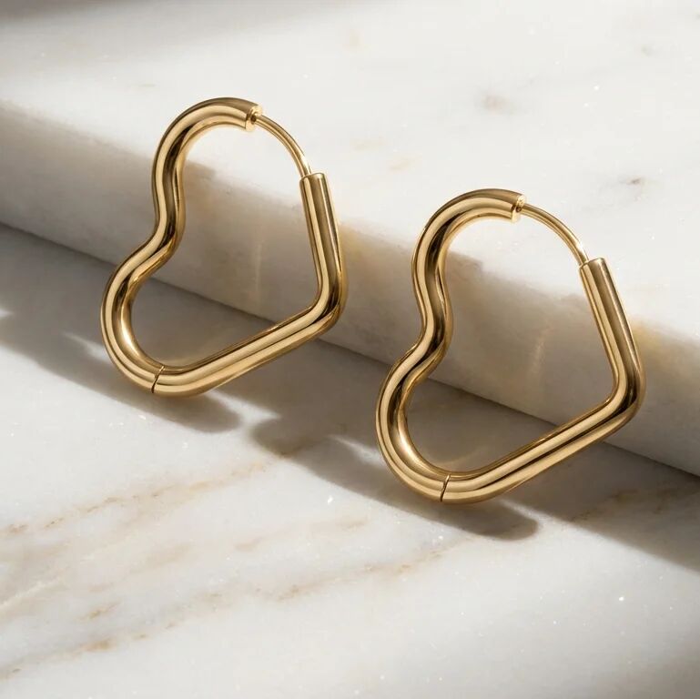 Heart Shaped gold hoop earrings on a marble surface