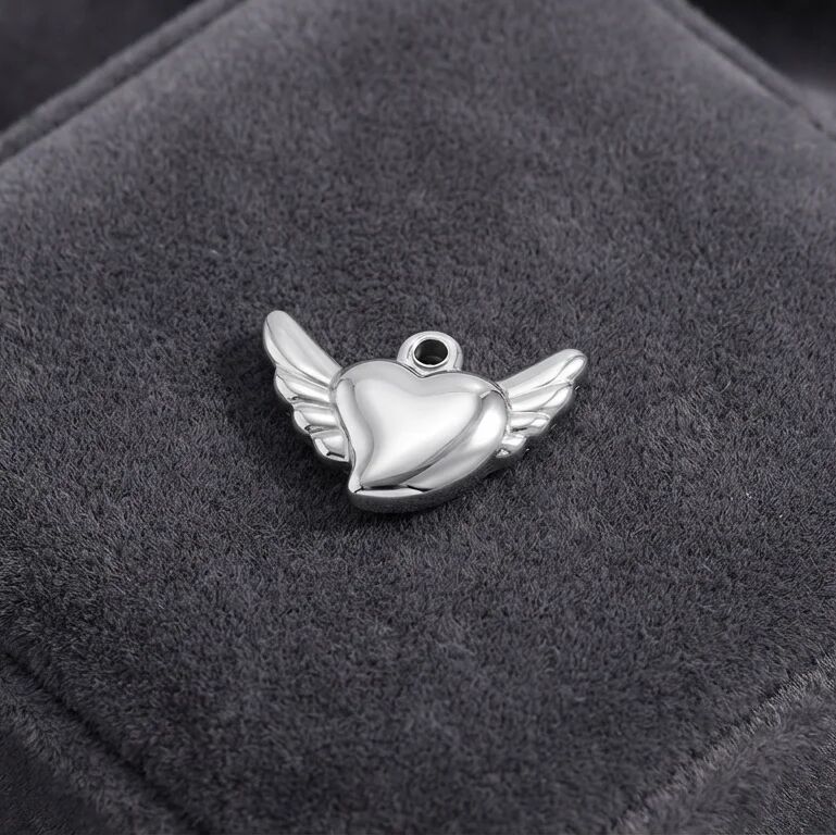 Silver heart-shaped pendant with wings on a dark gray background