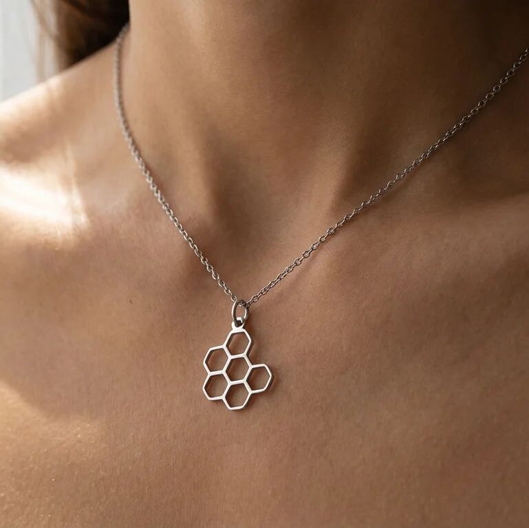 Necklace with a honeycomb pendant on a person's neck