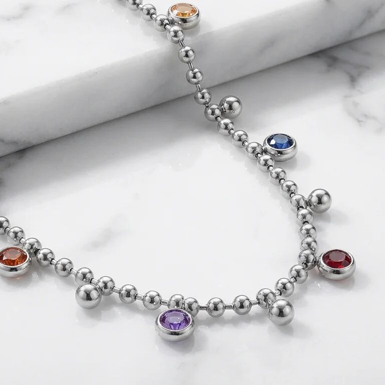 Silver beaded necklace with colorful gemstones on a marble surface