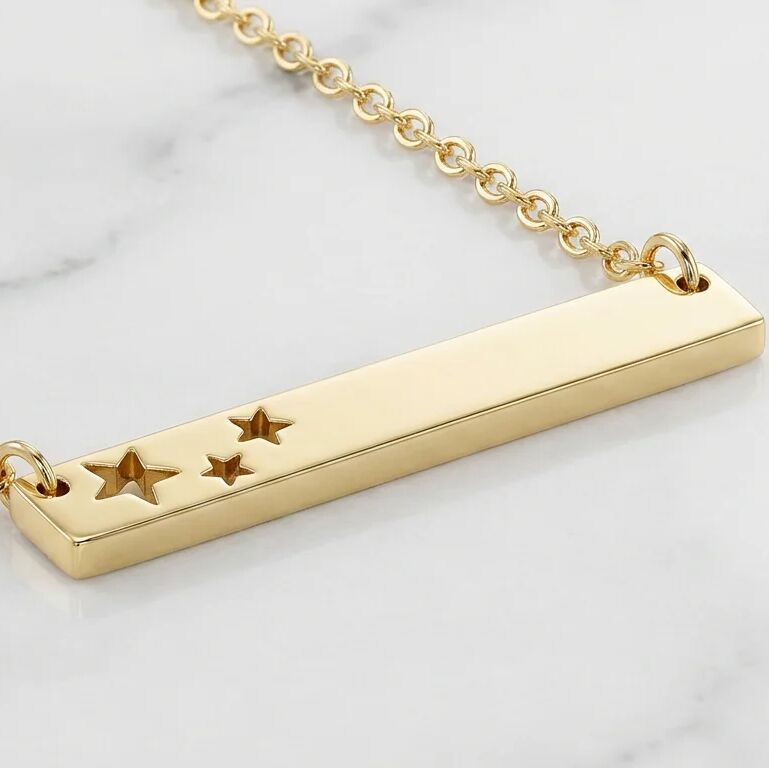 Gold necklace with star designs on a light background