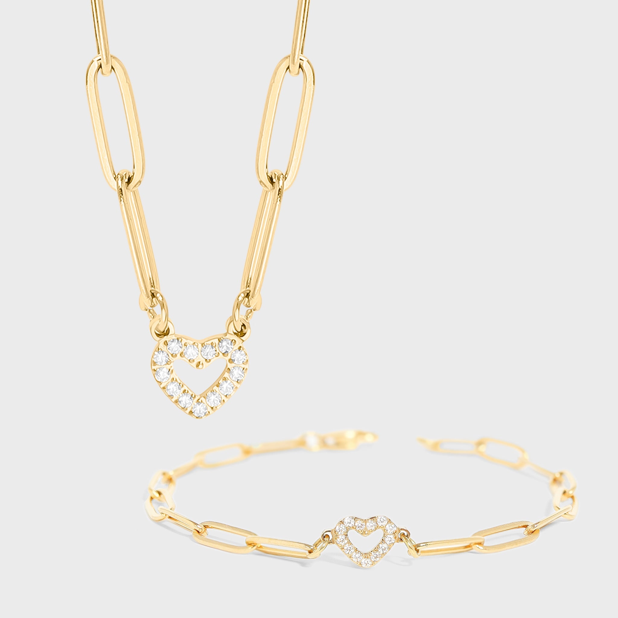 Gold necklace and bracelet set on a light gray background