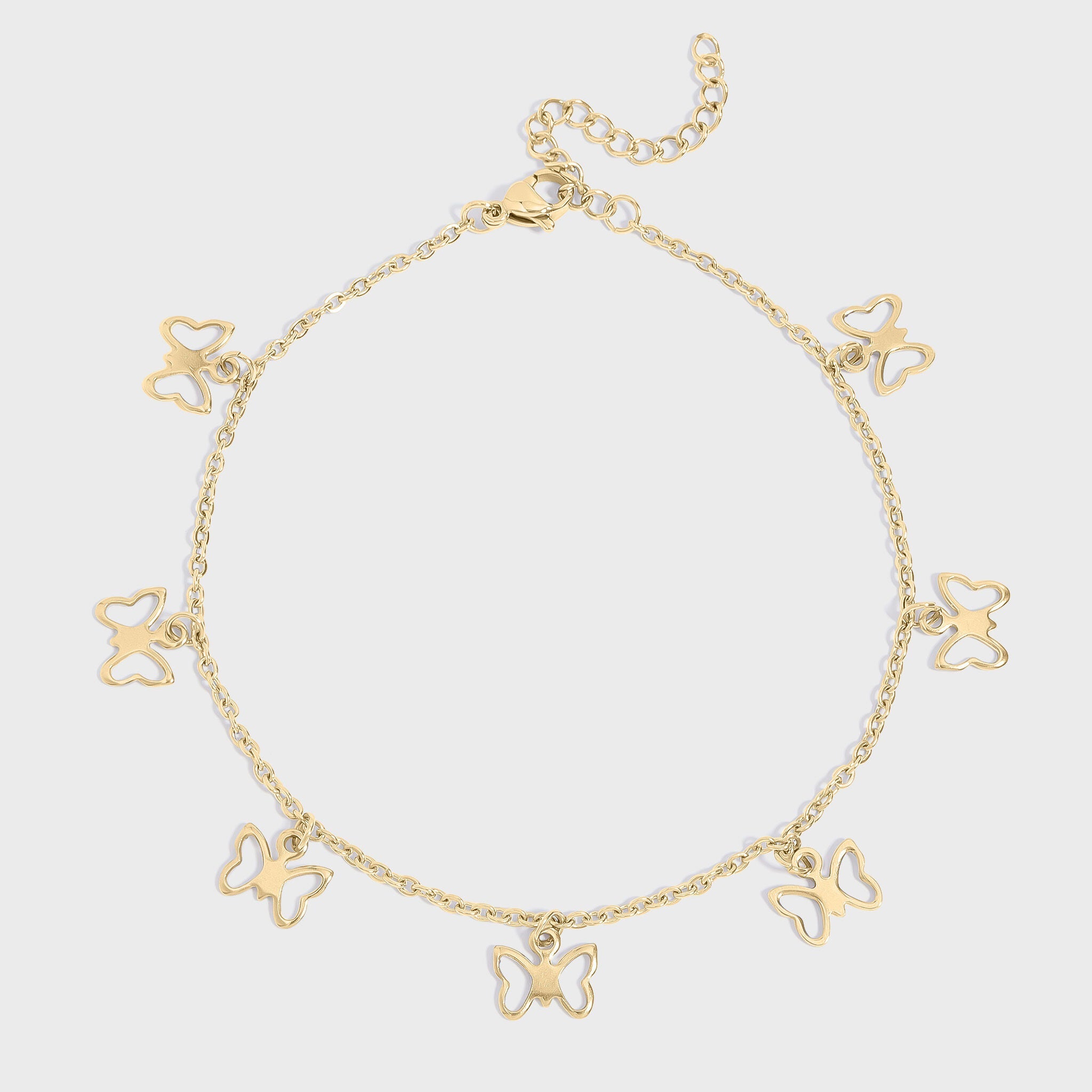 Gold butterfly charm anklet on a light gray background