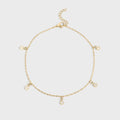 Gold bracelet with small charms on a light gray background
