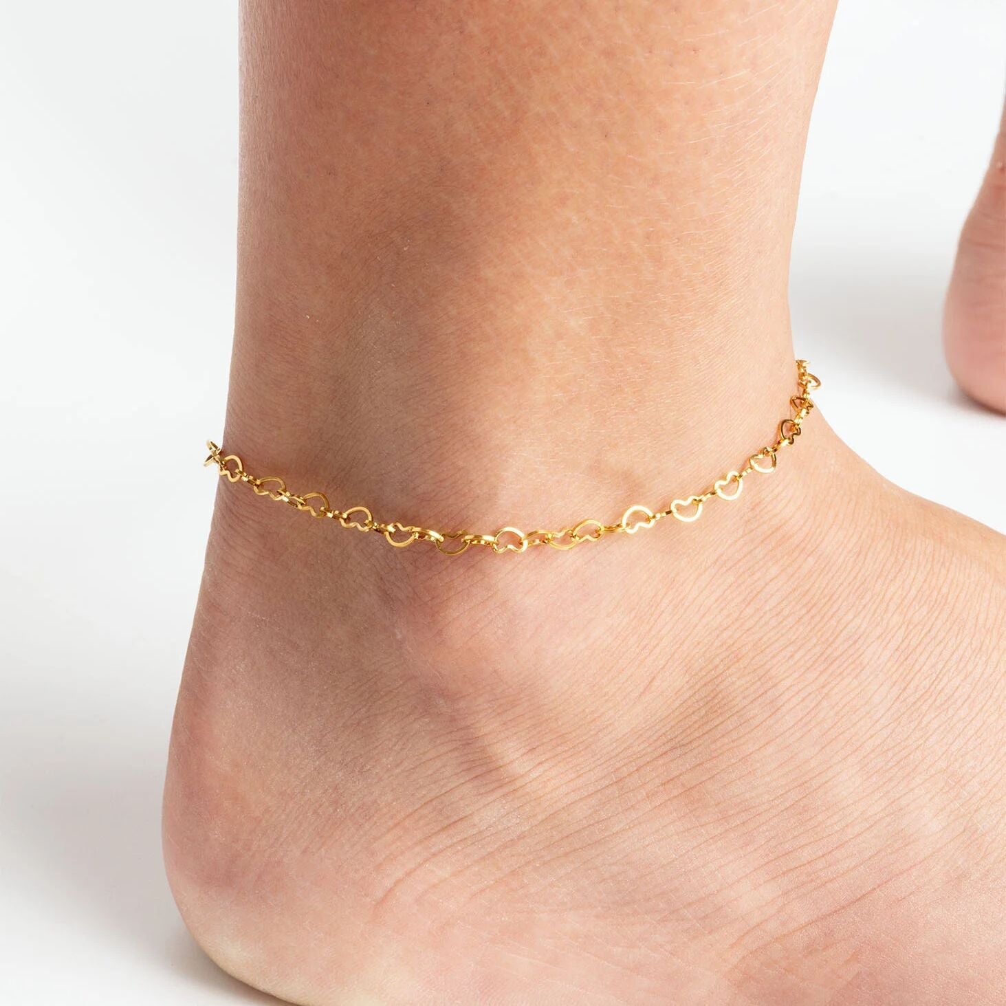 Gold Linked Hearts Anklet on a person's ankle against a white background