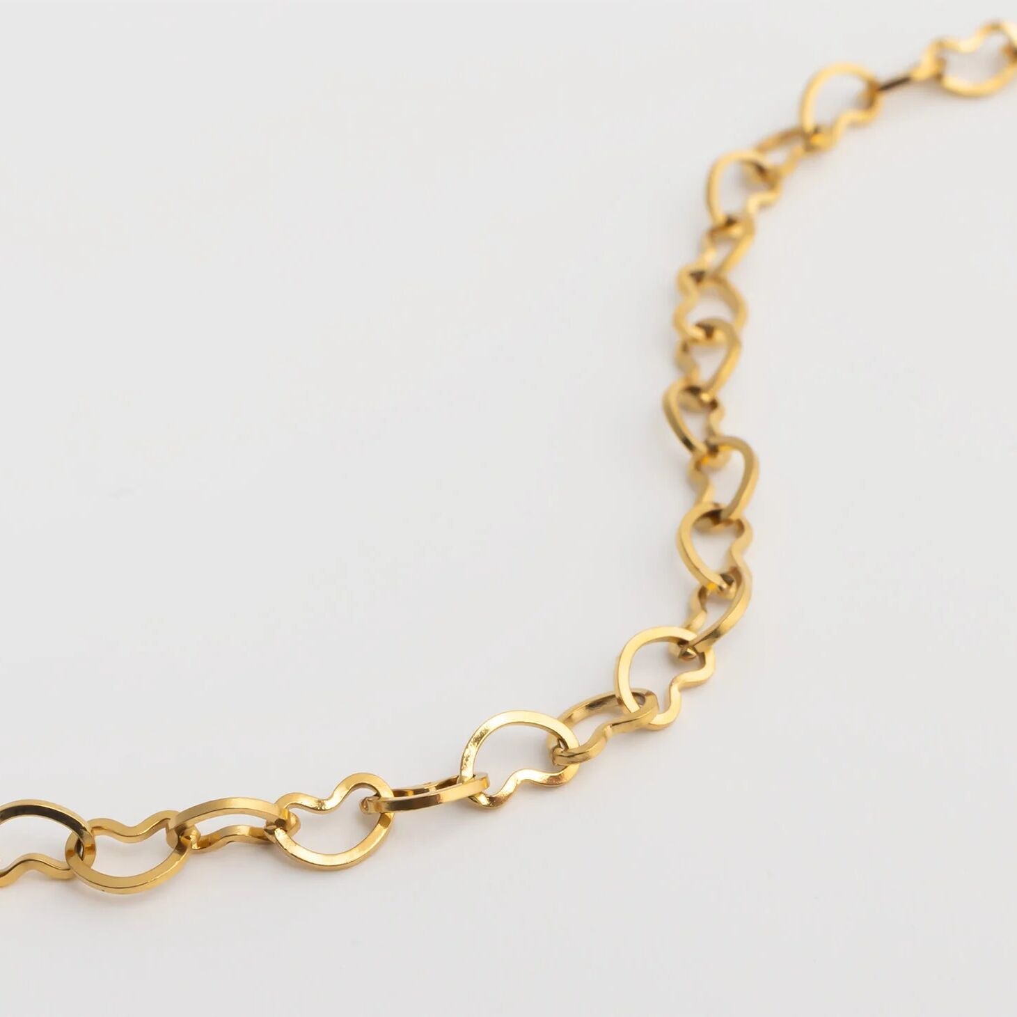 Gold chain Linked Hearts Anklet on a light gray background