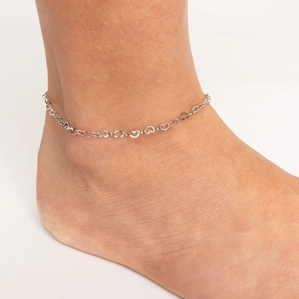 Silver Linked Hearts Anklet on a person's ankle against a white background