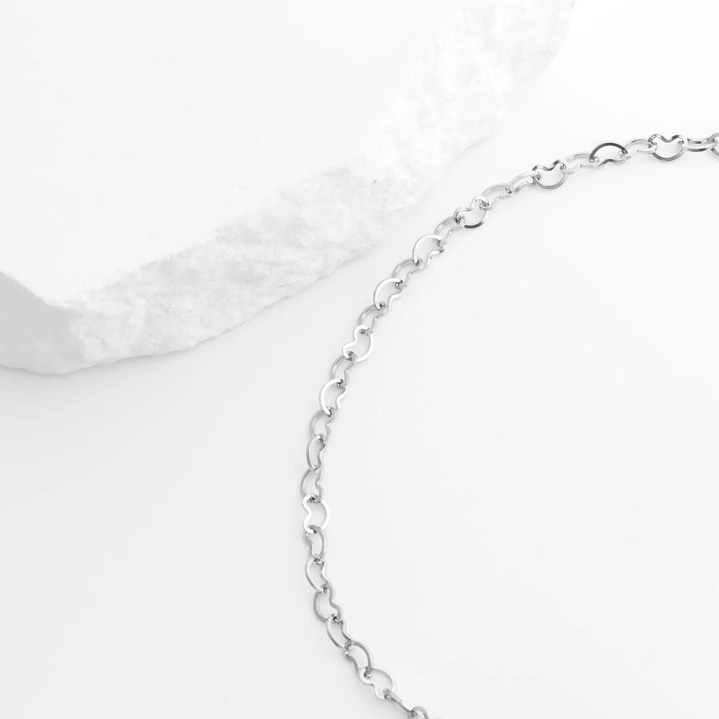 Silver chain Linked Hearts Anklet on a white satin background