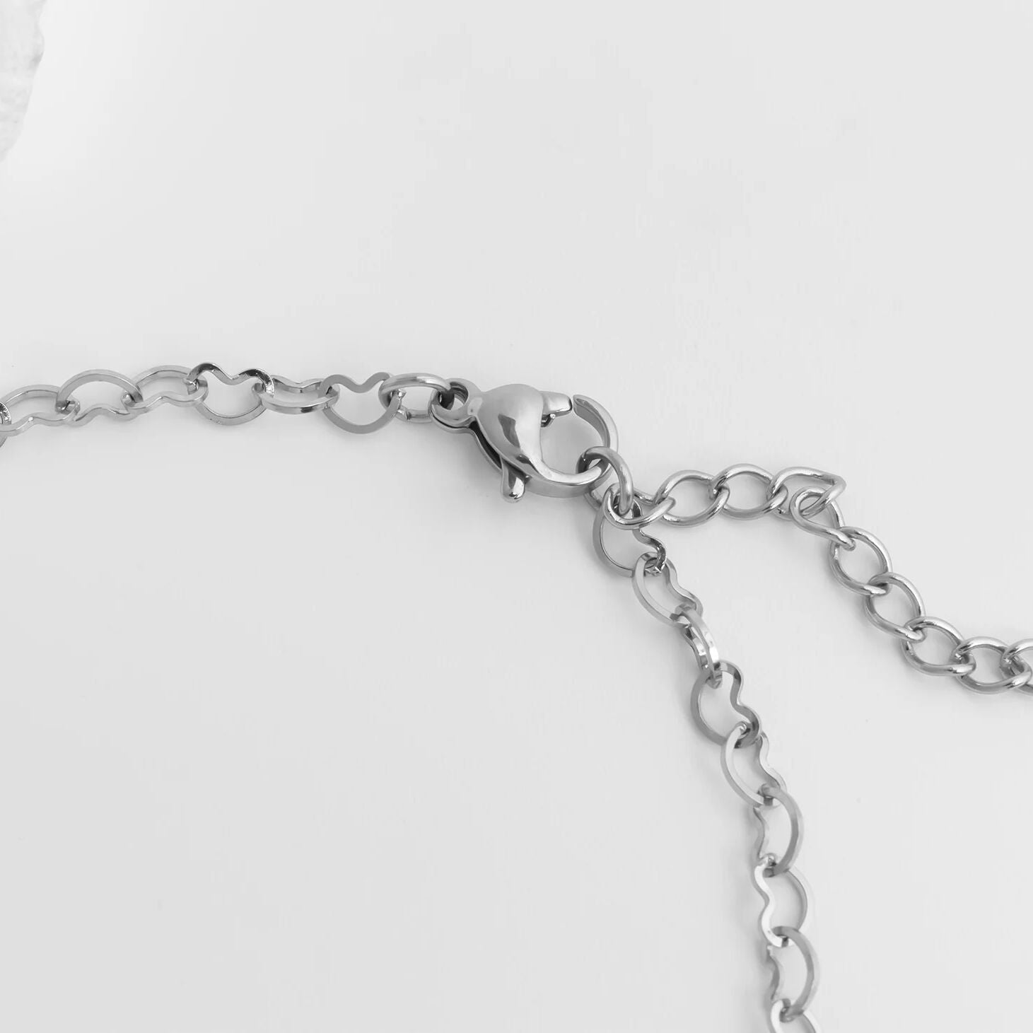 Silver chain Linked Hearts Anklet on a light gray background