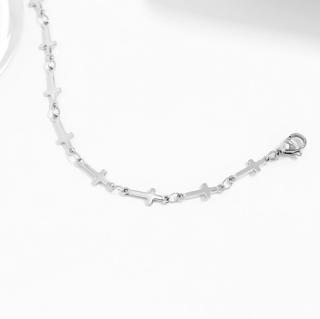 Silver cross bracelet with cross designs on a white background