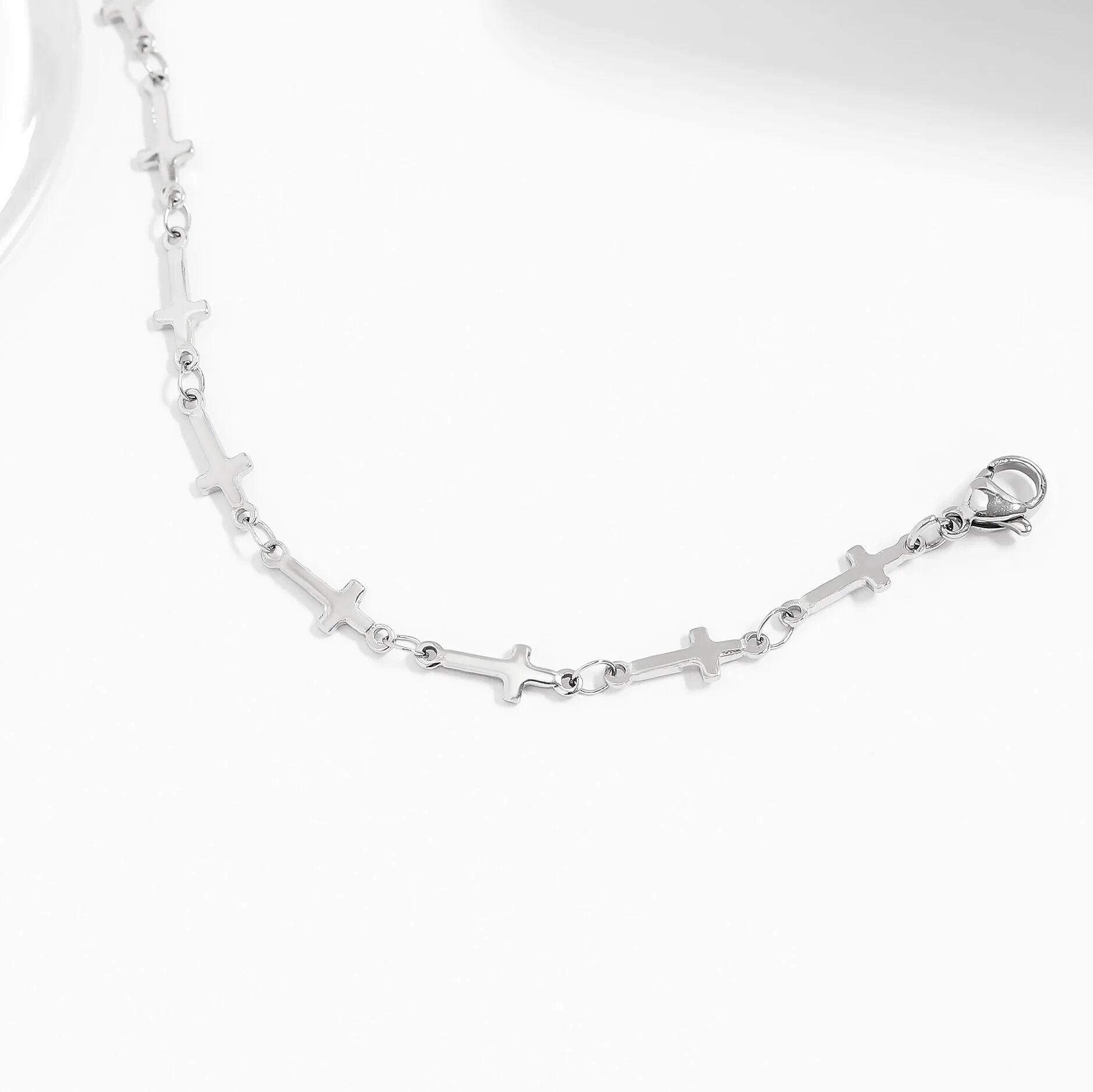 Silver cross bracelet with cross designs on a white background