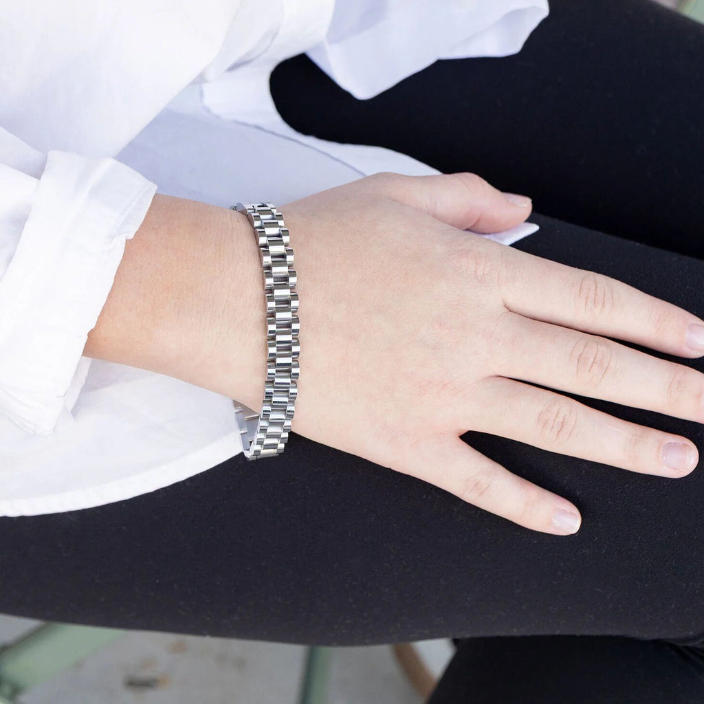 Person wearing a silver bracelet on a blurred background