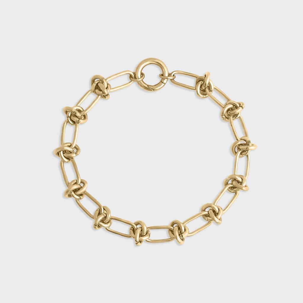 Gold chain bracelet on a light gray background