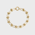 Gold chain bracelet on a light gray background