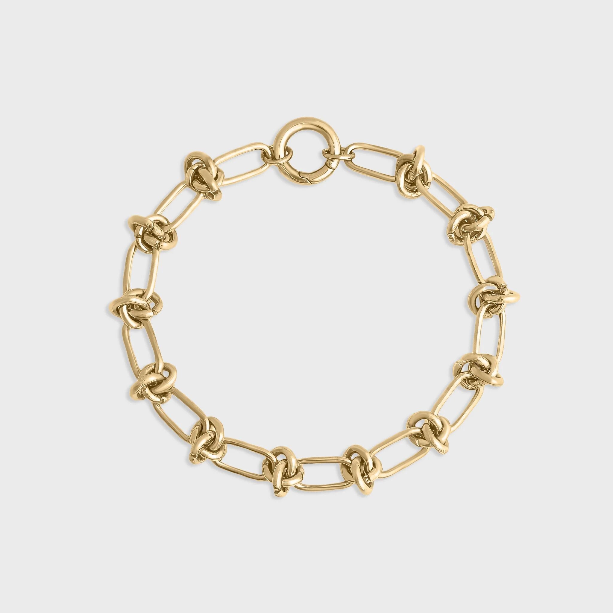 Gold chain bracelet on a light gray background