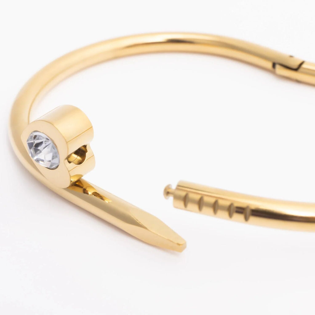 Gold bracelet with a clear gemstone on a white background