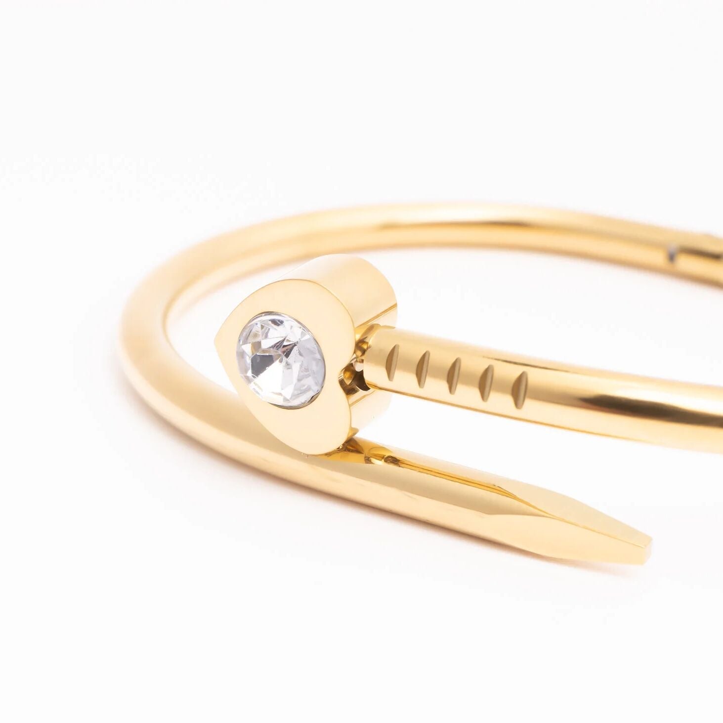 Gold bracelet with a clear gemstone on a white background