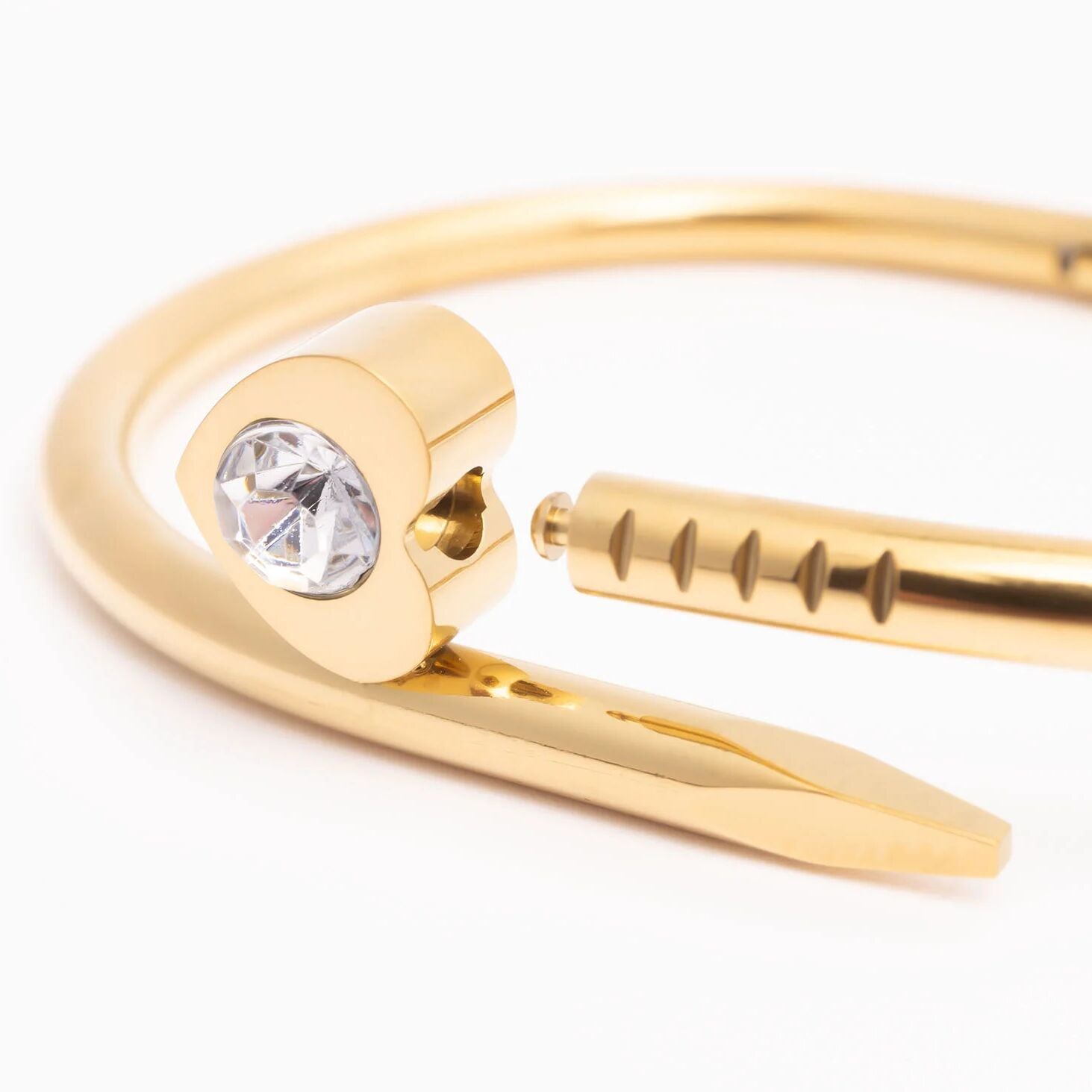 Gold bangle with a clear gemstone on a white background