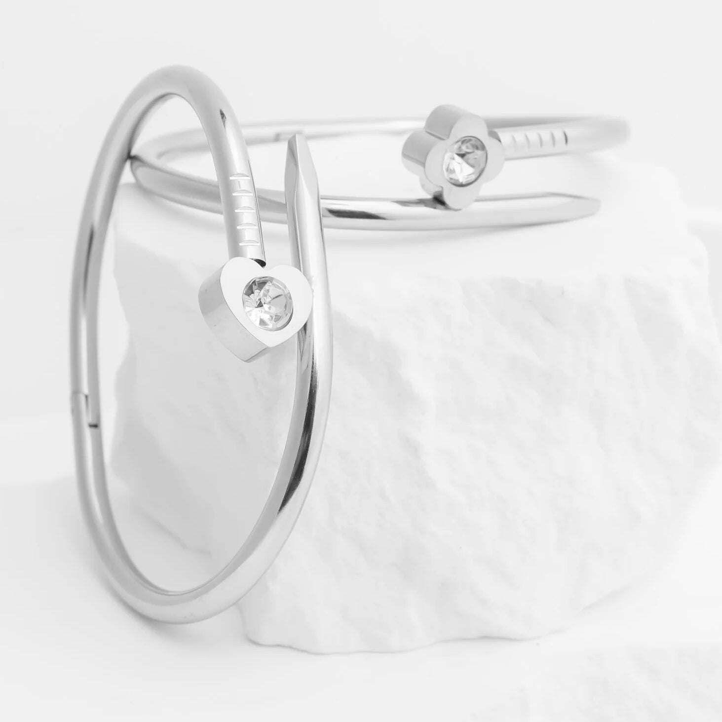 Silver bracelet with heart-shaped charms on a light gray background