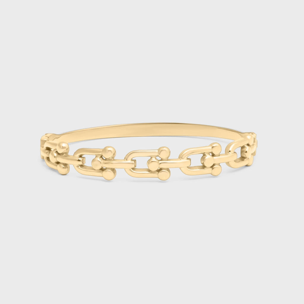 Gold chain bracelet on a light gray background