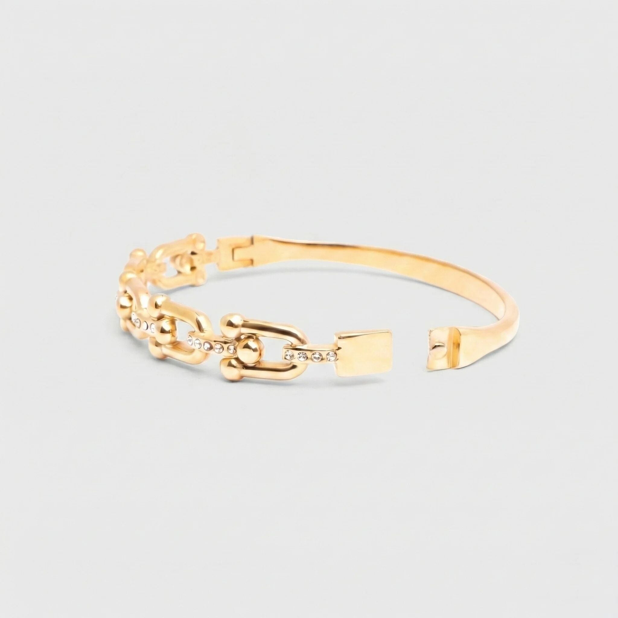 Gold chain bracelet on a light gray background