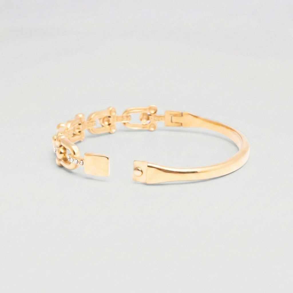 Gold bracelet on a light gray background
