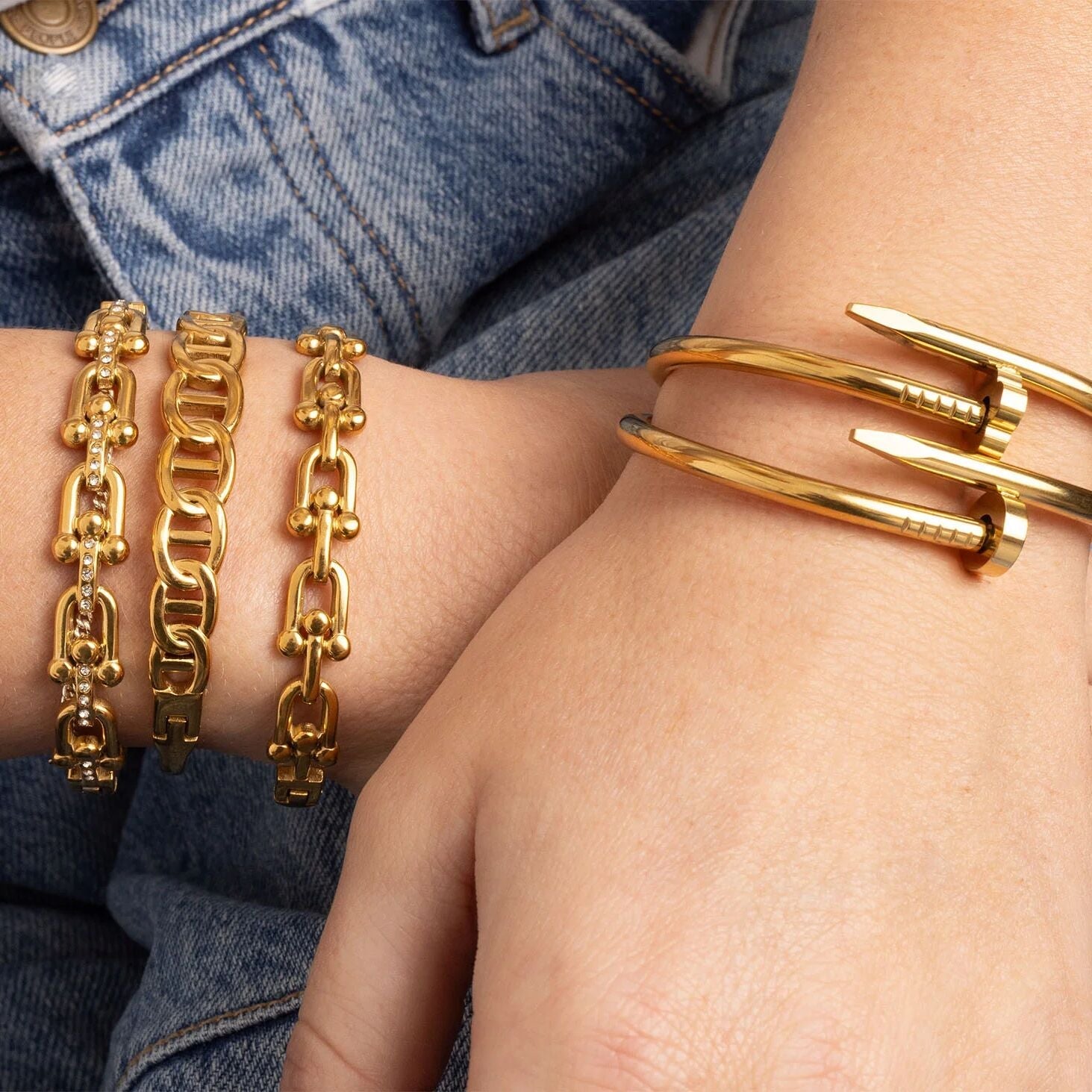 Gold bracelets on a person's wrist with denim background
