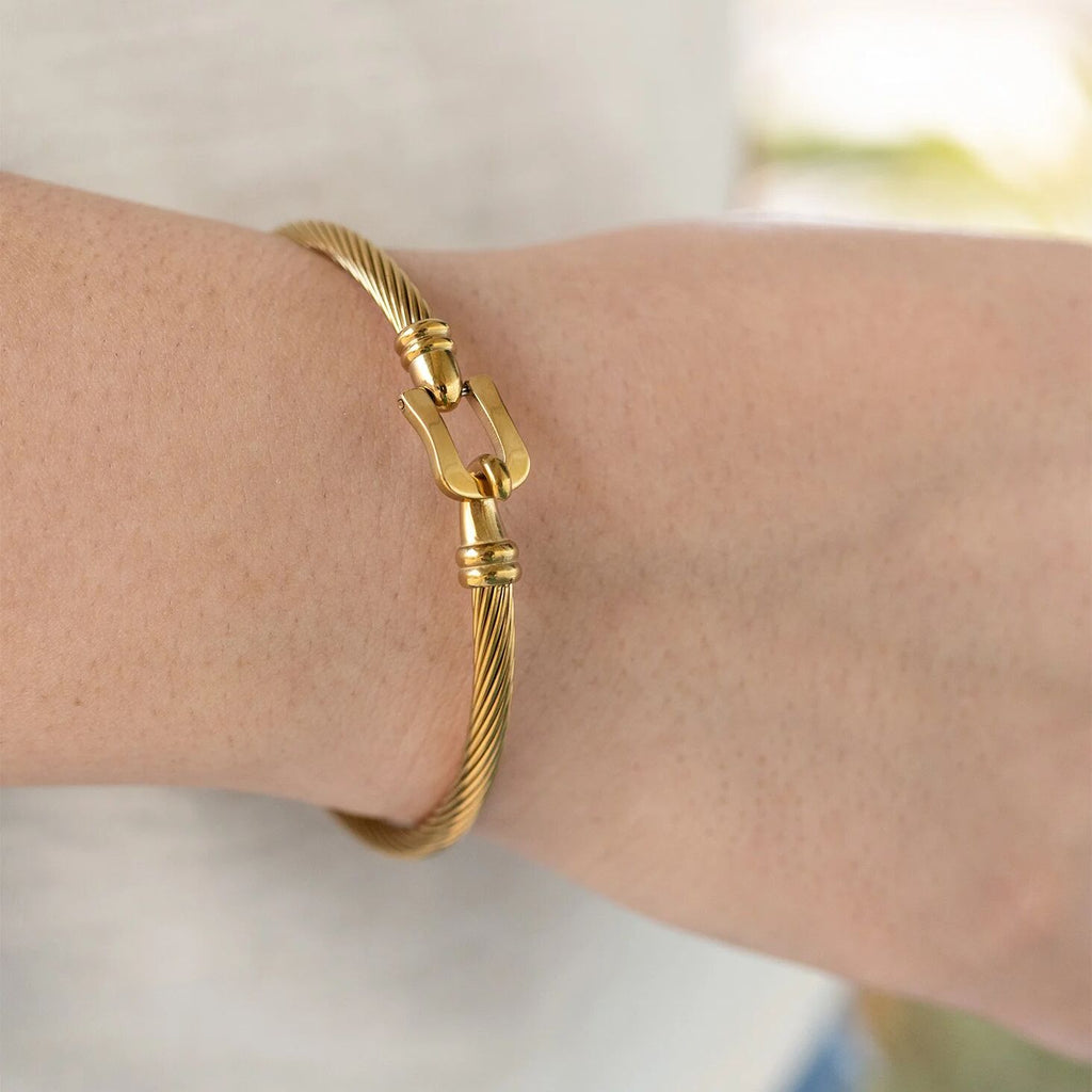Gold bracelet on a wrist with a blurred background