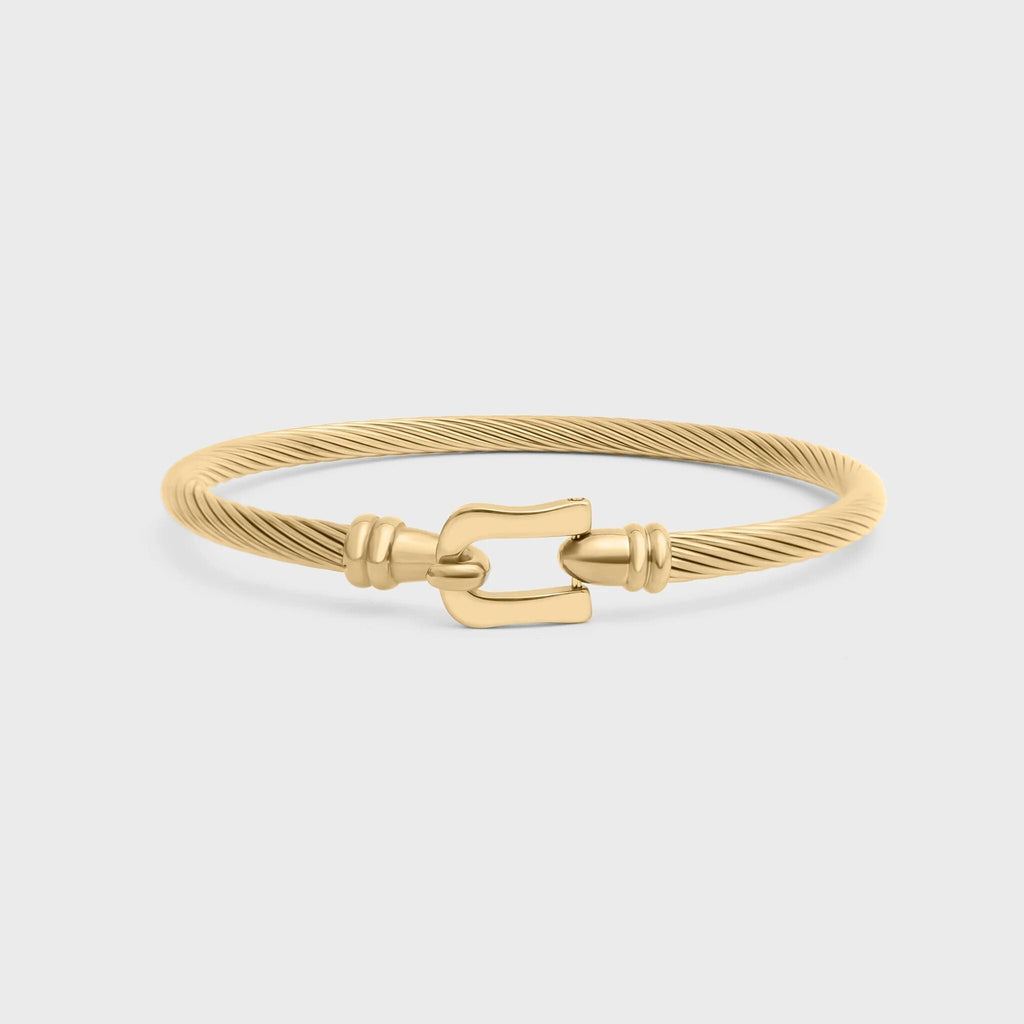Gold bracelet with a clasp on a light gray background