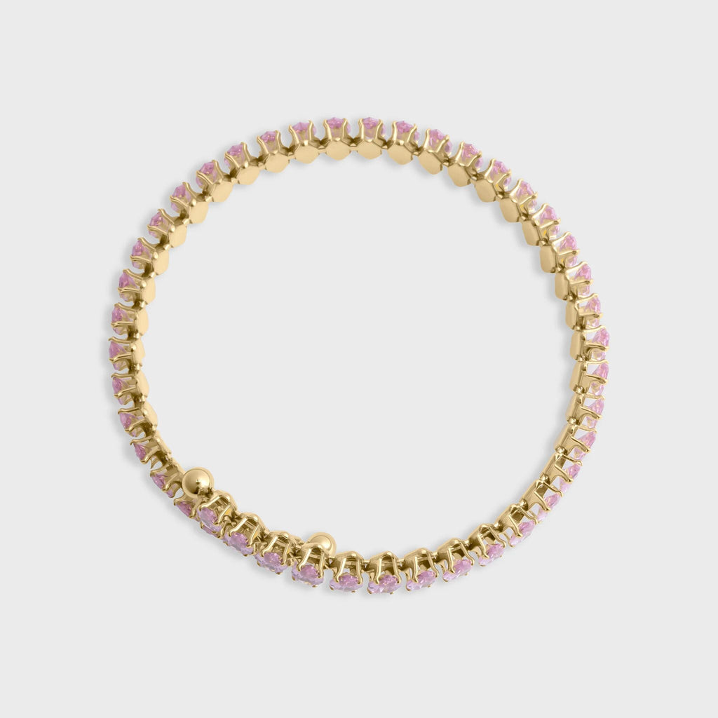 Gold bracelet with pink stones on a light gray background