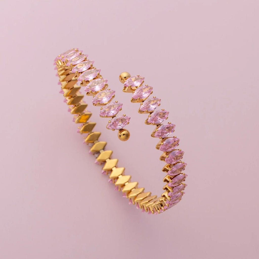 Gold and pink jewelry set on a pink background