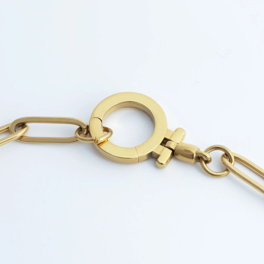 Gold chain necklace on a light gray background