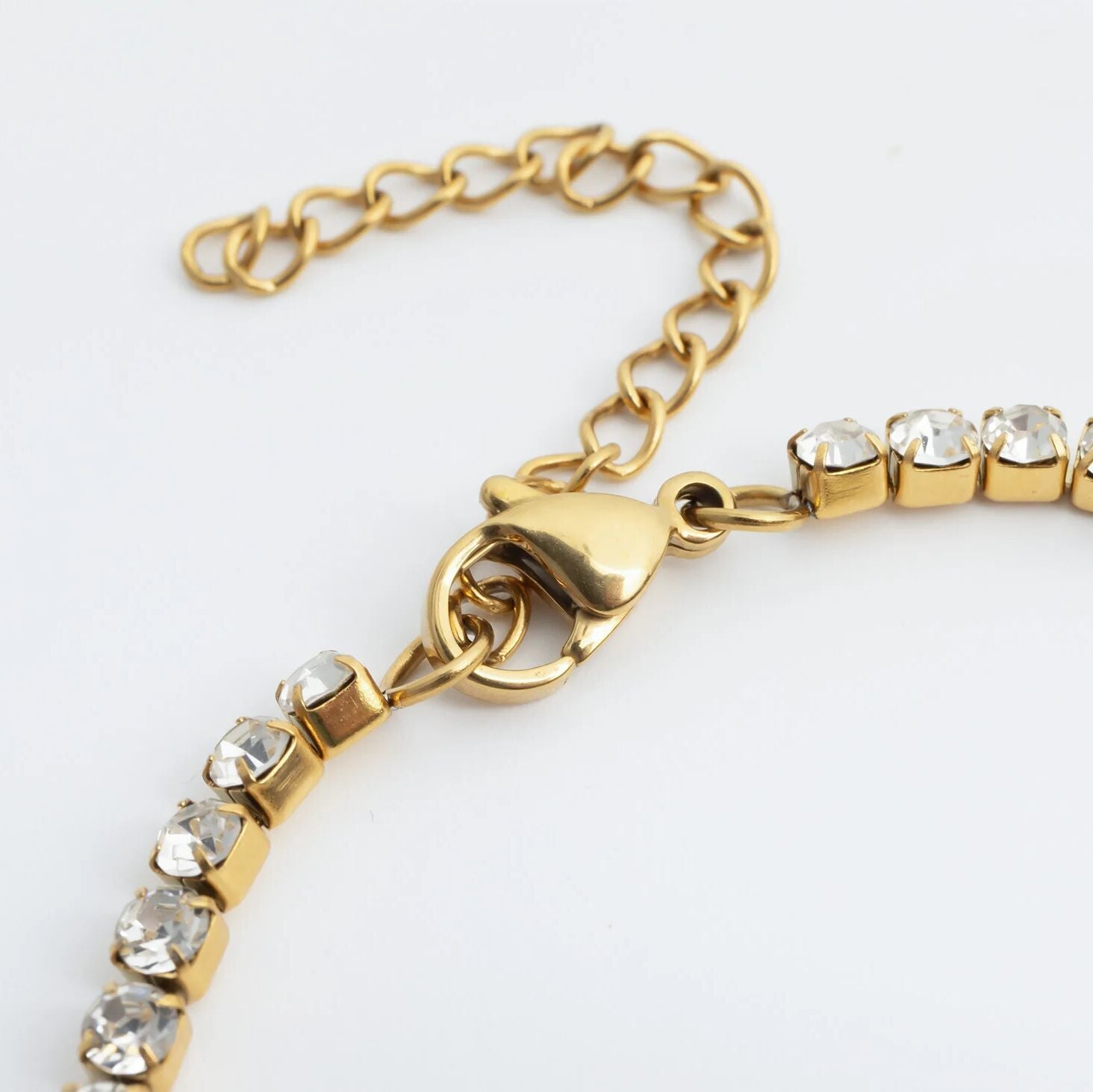 Gold bracelet with crystal beads on a white background