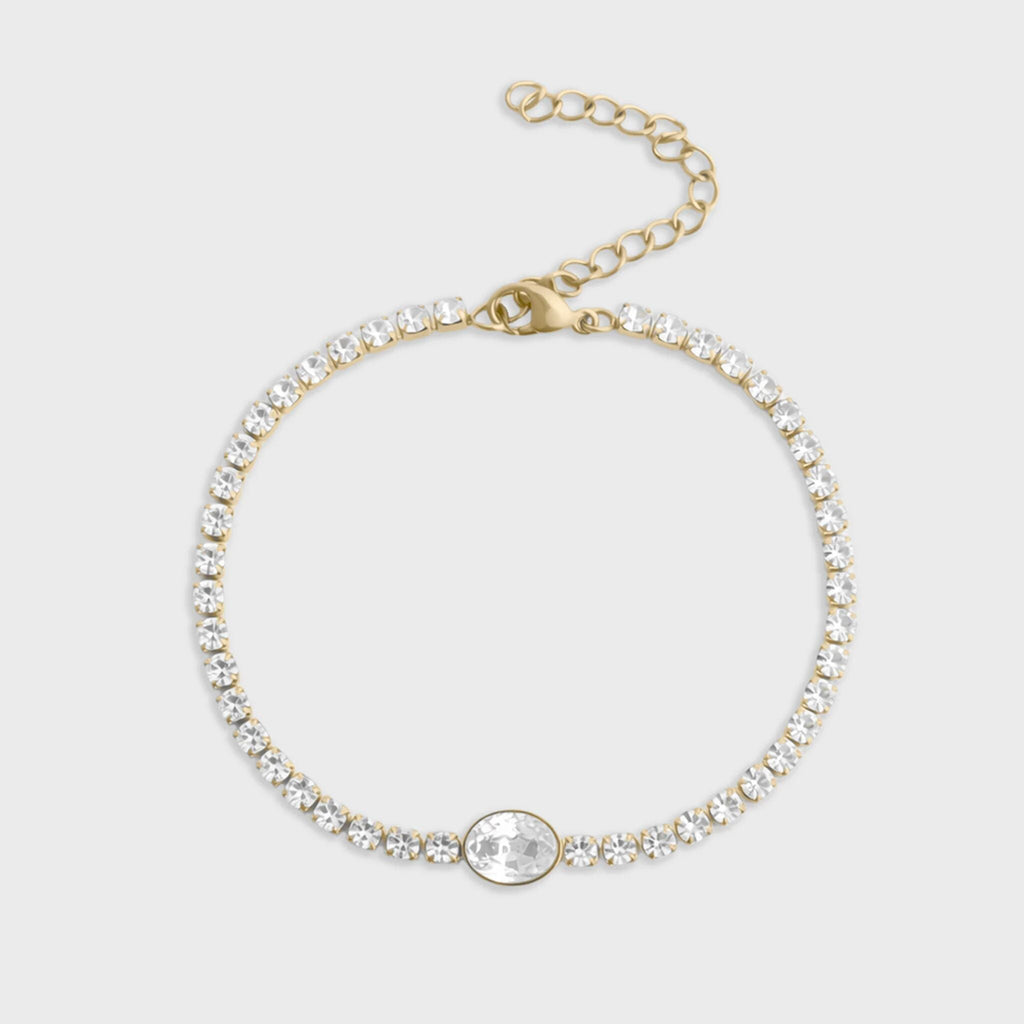 Gold bracelet with clear gemstones on a light gray background