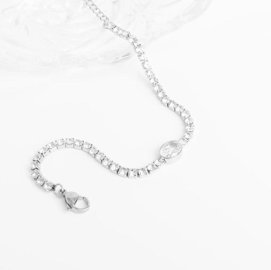 Silver bracelet with clear gemstones on a white background