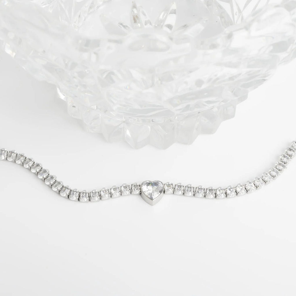 Silver bracelet with a heart-shaped clasp on a white background