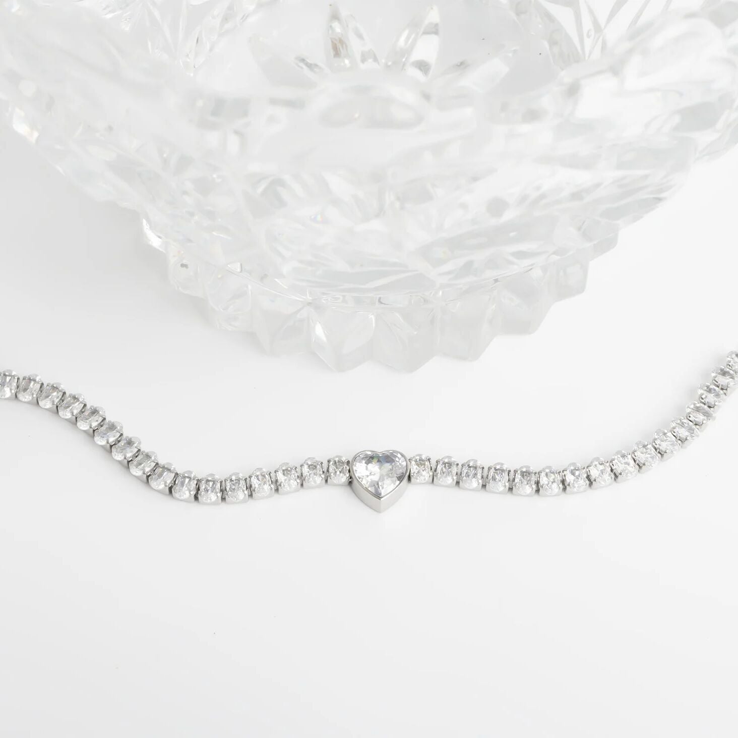 Silver bracelet with a heart-shaped clasp on a white background