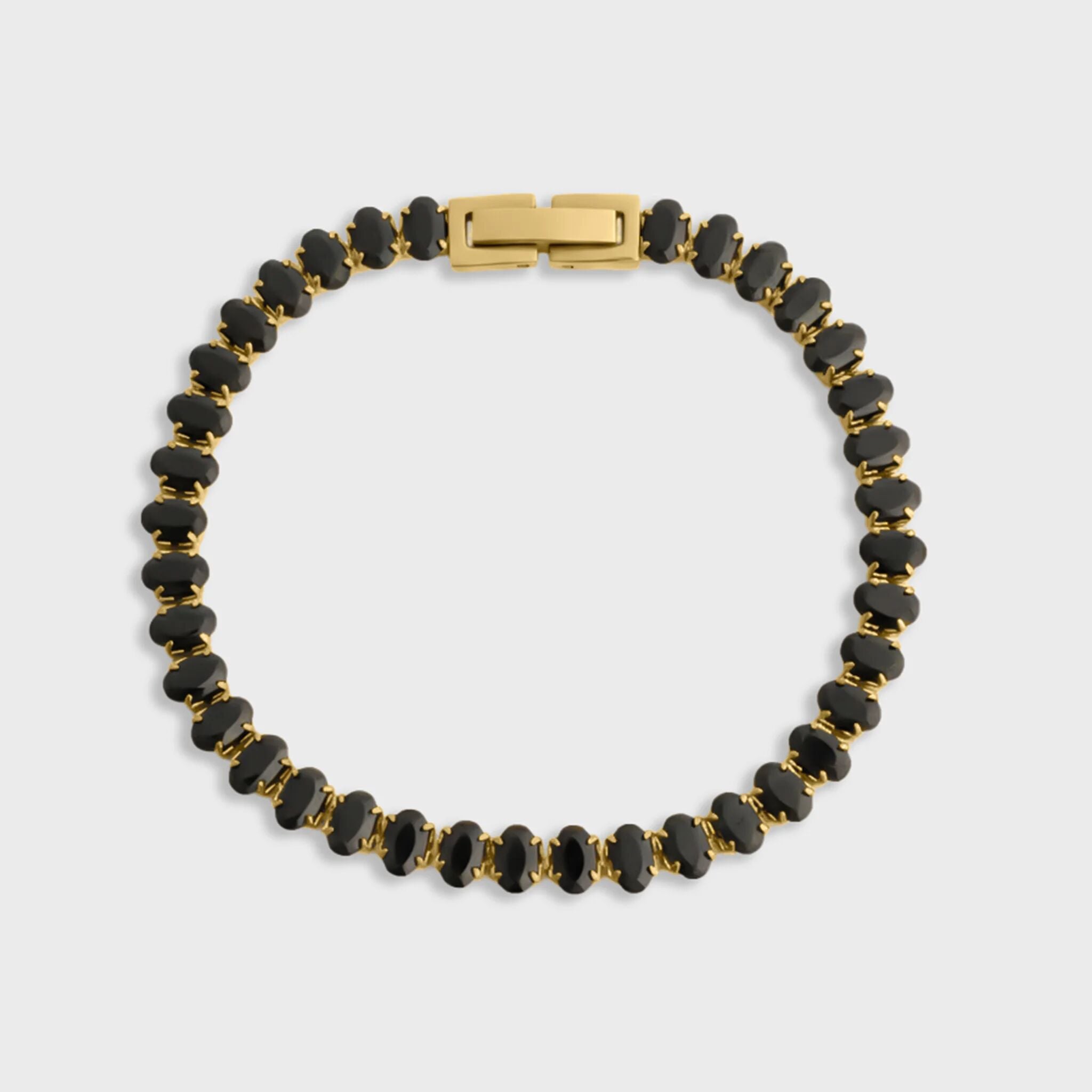 Black beaded bracelet with gold clasp on a light gray background