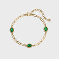 Gold bracelet with green gemstones on a white background