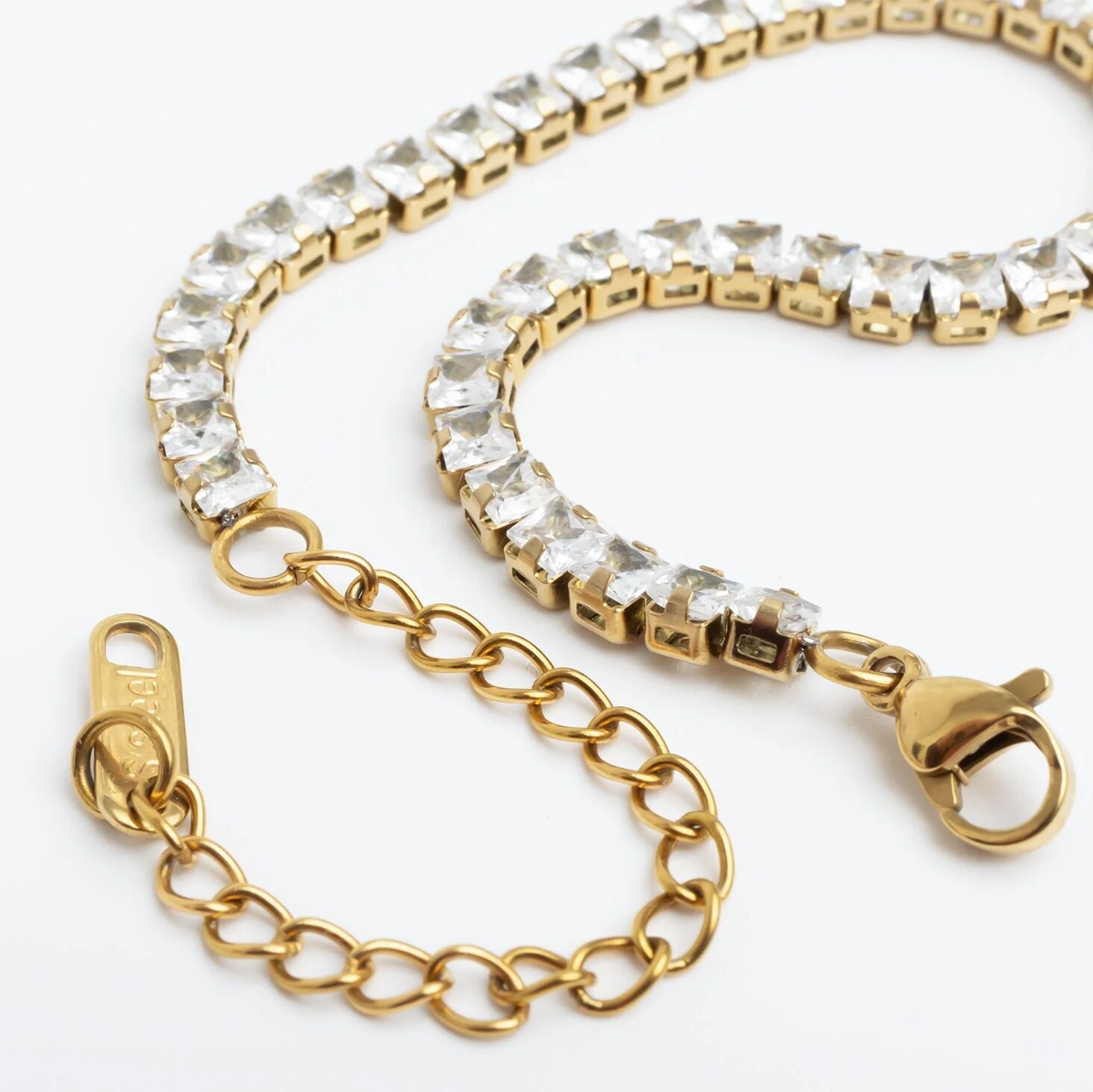 Gold chain with crystal-encrusted clasp on a white background