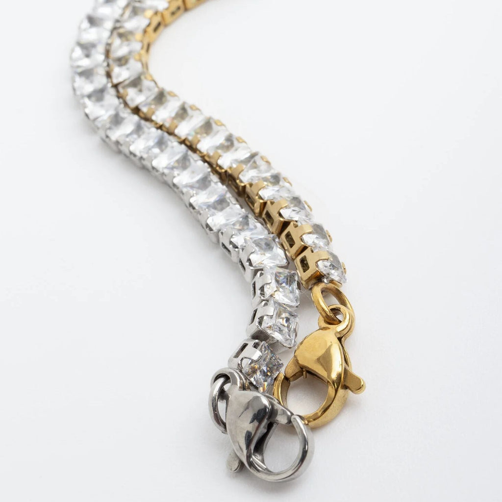 Gold and silver bracelet with clear gemstones on a white background