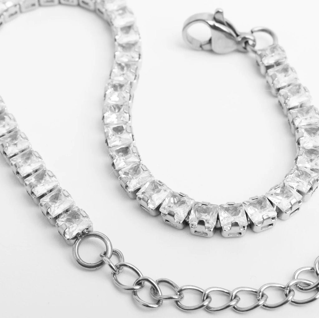 Silver bracelet with clear gemstones on a white background