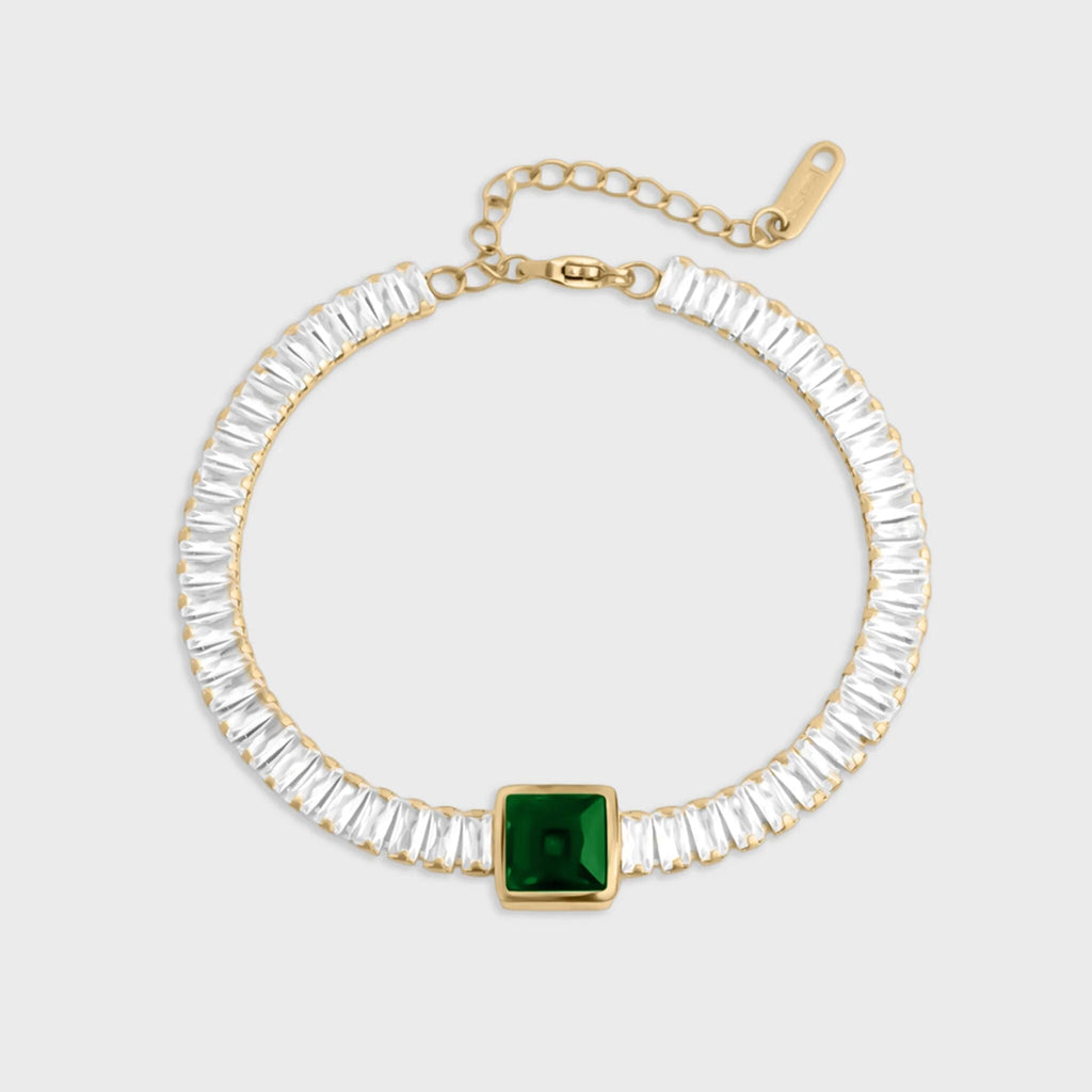 Bracelet with clear gemstones and a green square stone on a white background