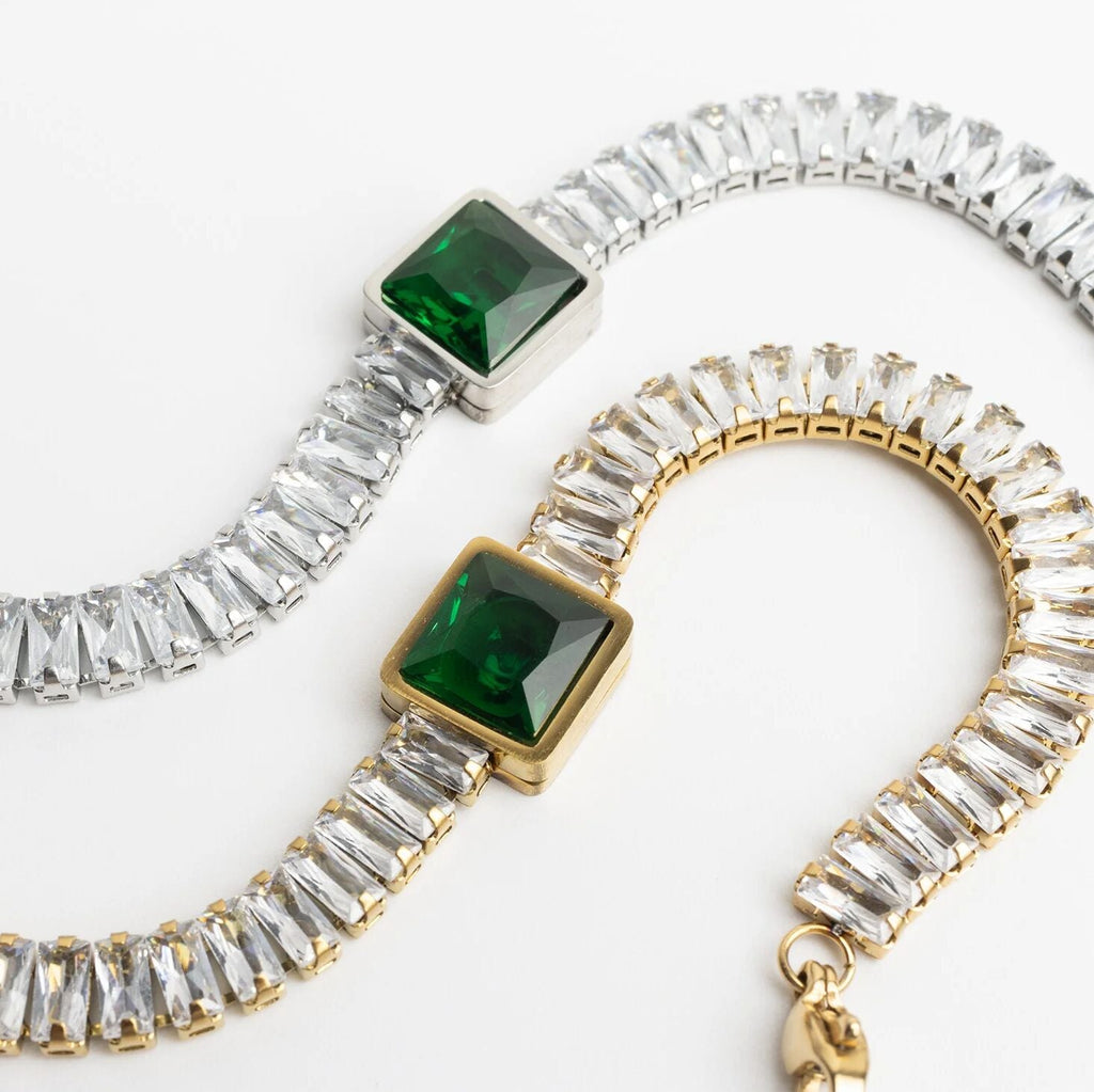 Two bracelets with green gemstones and clear stones on a white background