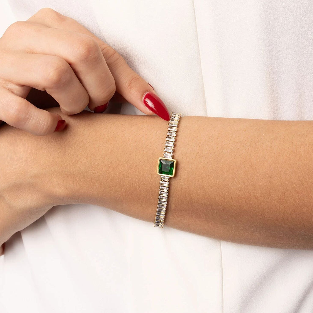 Silver bracelet with a green gemstone on a wrist against a white background
