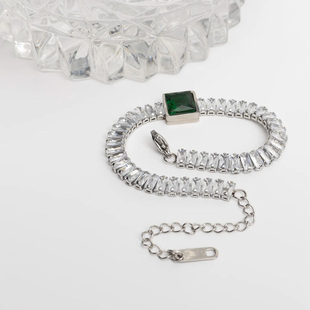 Silver bracelet with a green gemstone on a white background