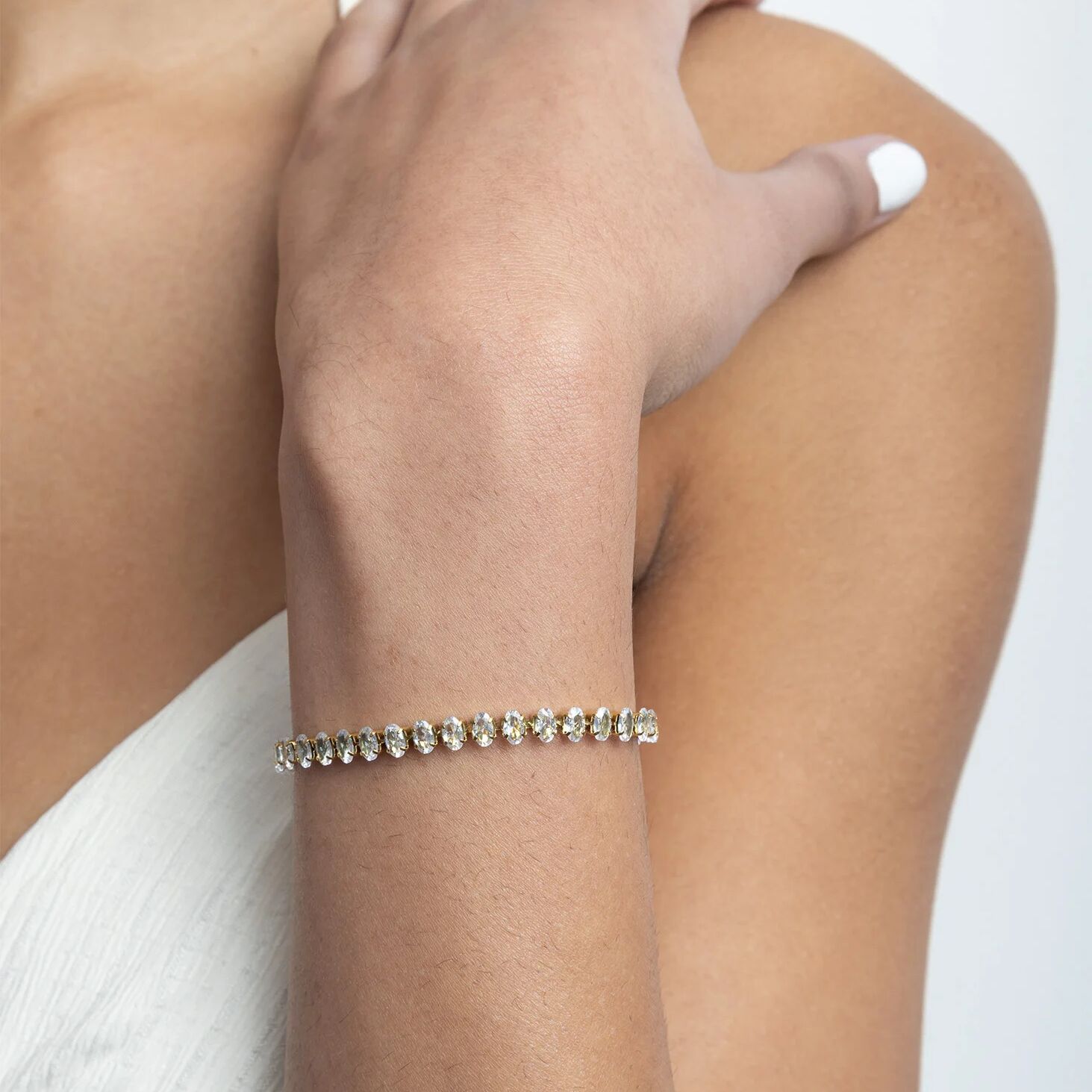 Close-up of a person's arm wearing a bracelet on a plain background