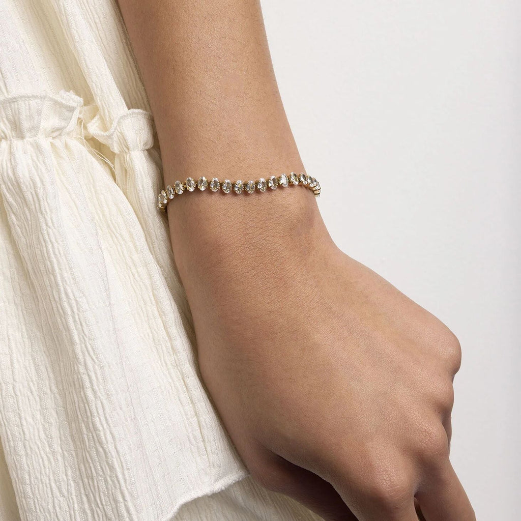 Bracelet on a wrist with a plain background