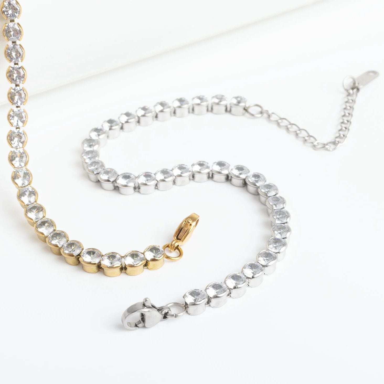 Two necklaces, one gold and one silver, on a white background